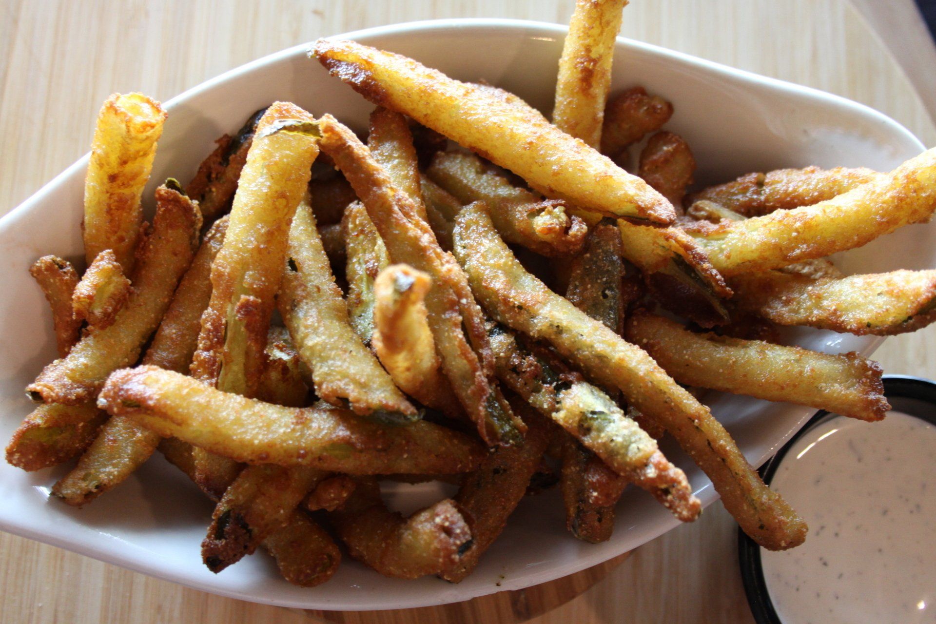 A bowl of french fries next to a bowl of dipping sauce