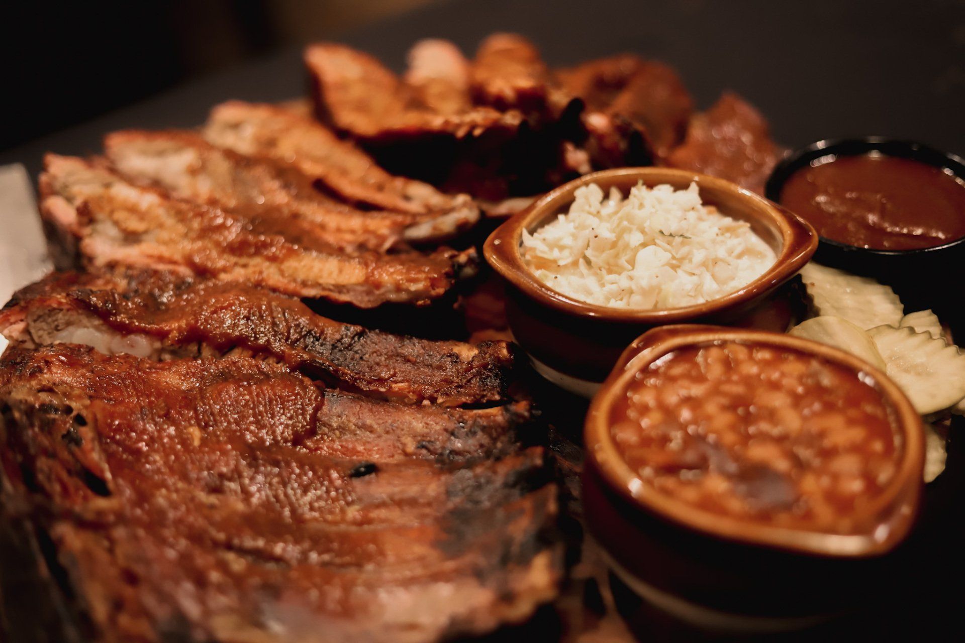 Ribs , beans , potatoes , and sauces at authentic smokehouse bbq