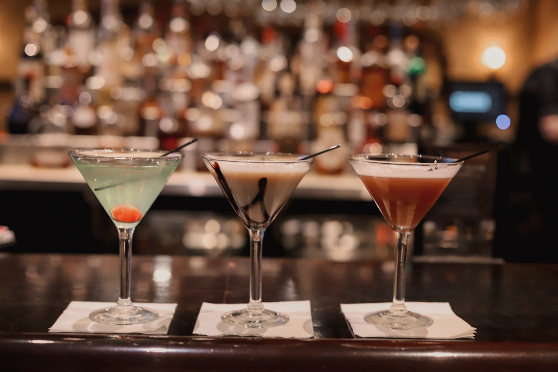 Three martini glasses are lined up on a bar - Smokehouse bbq restaurant kansas city 