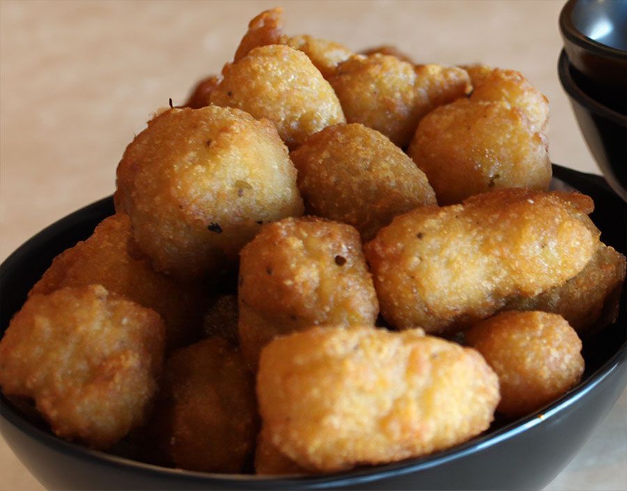 A bowl of fried food next to a bowl of dipping sauce in smokehouse barbecue