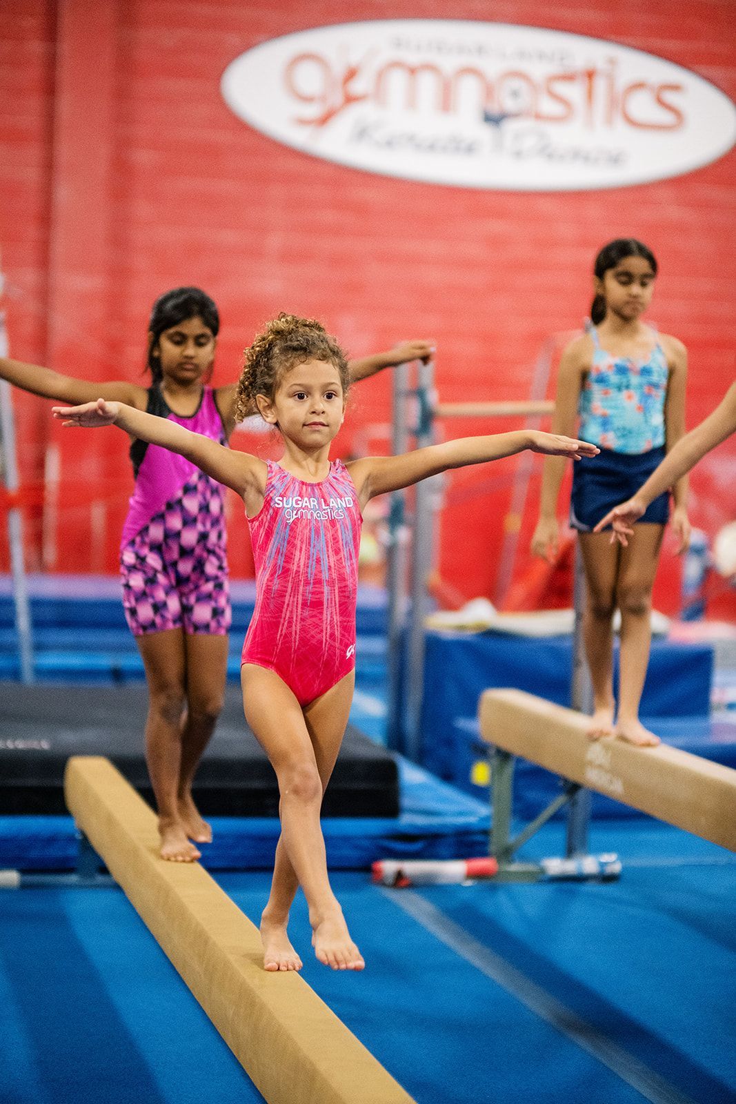 A little girl is doing a handstand on a mat.