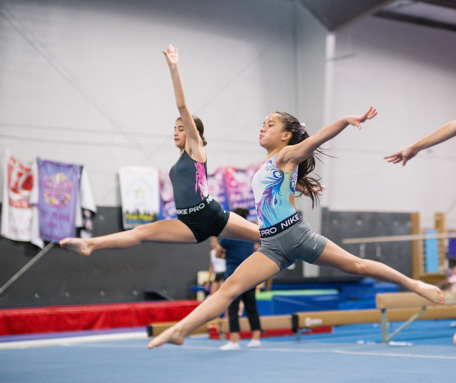 A group of young girls are practicing gymnastics in a gym.