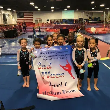 A group of young girls holding a sign that says 2nd place level 1 medium team