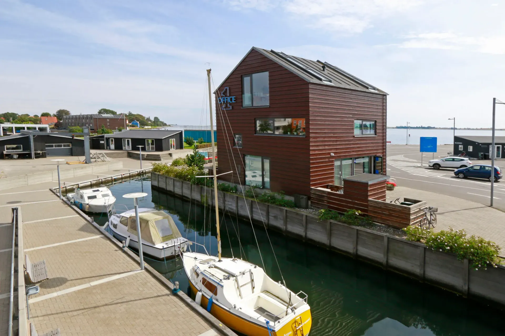 En båd ligger foran en bygning ved siden af en kanal