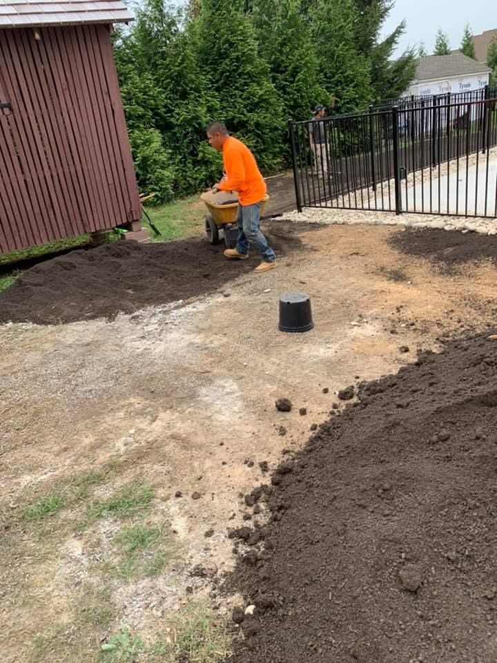 Stone steps lead up through a lush garden with white and pink flowering shrubs and a planter on a stacked stone wall.