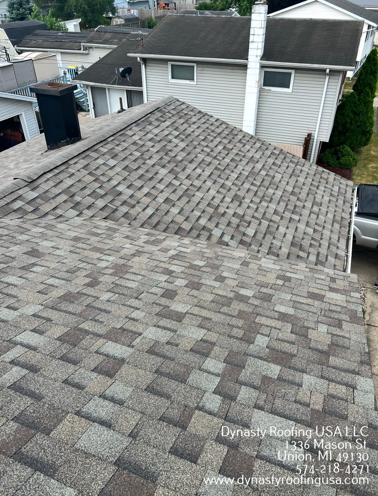 Gray shingle roofs of houses in a neighborhood. Rooftop view, sunny day.