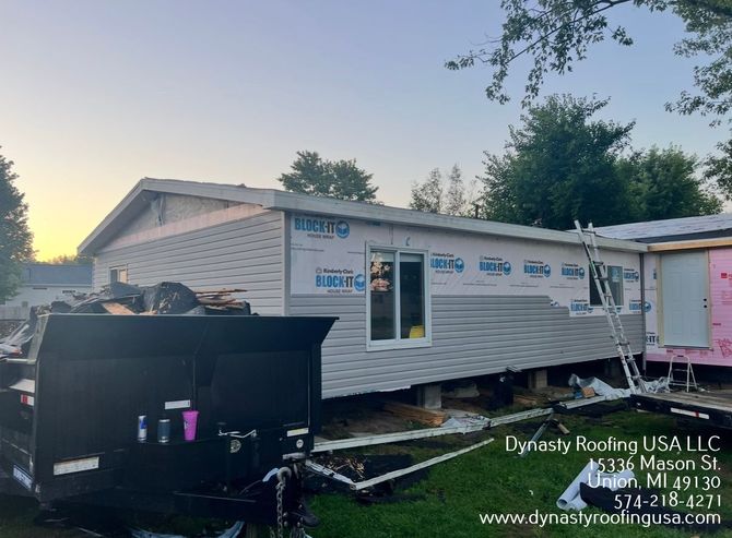 House under construction with siding, wrap, and window installation.
