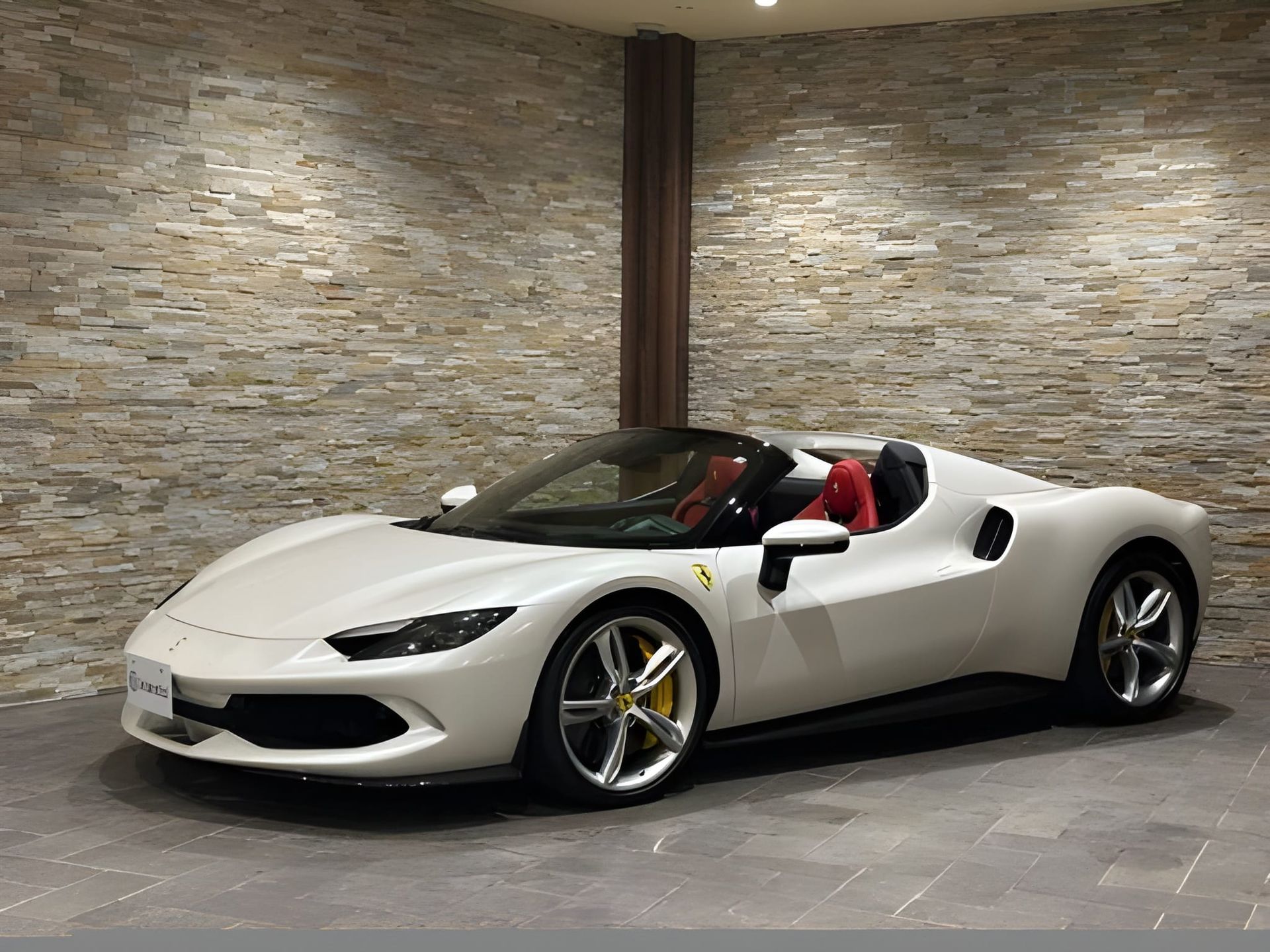 White Ferrari sports car parked in front of a stone wall.