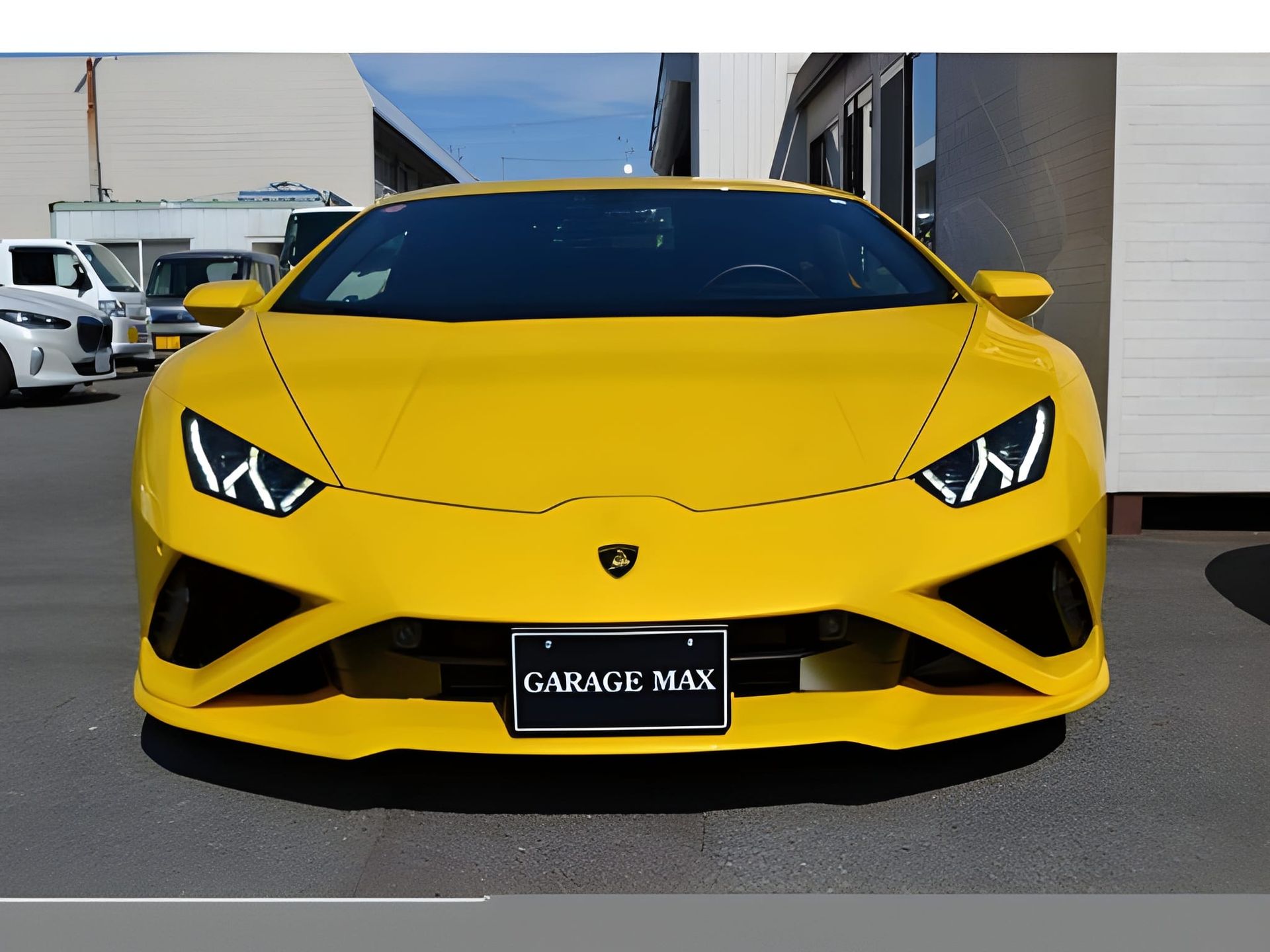 Yellow Lamborghini Huracan sports car parked in front of a building.