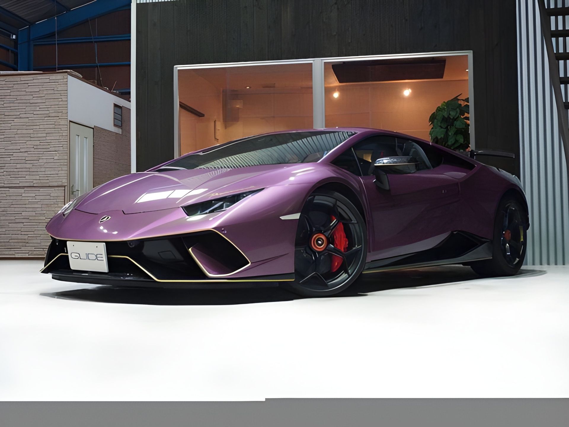 Pink Lamborghini Huracan with gold trim, parked inside a garage.