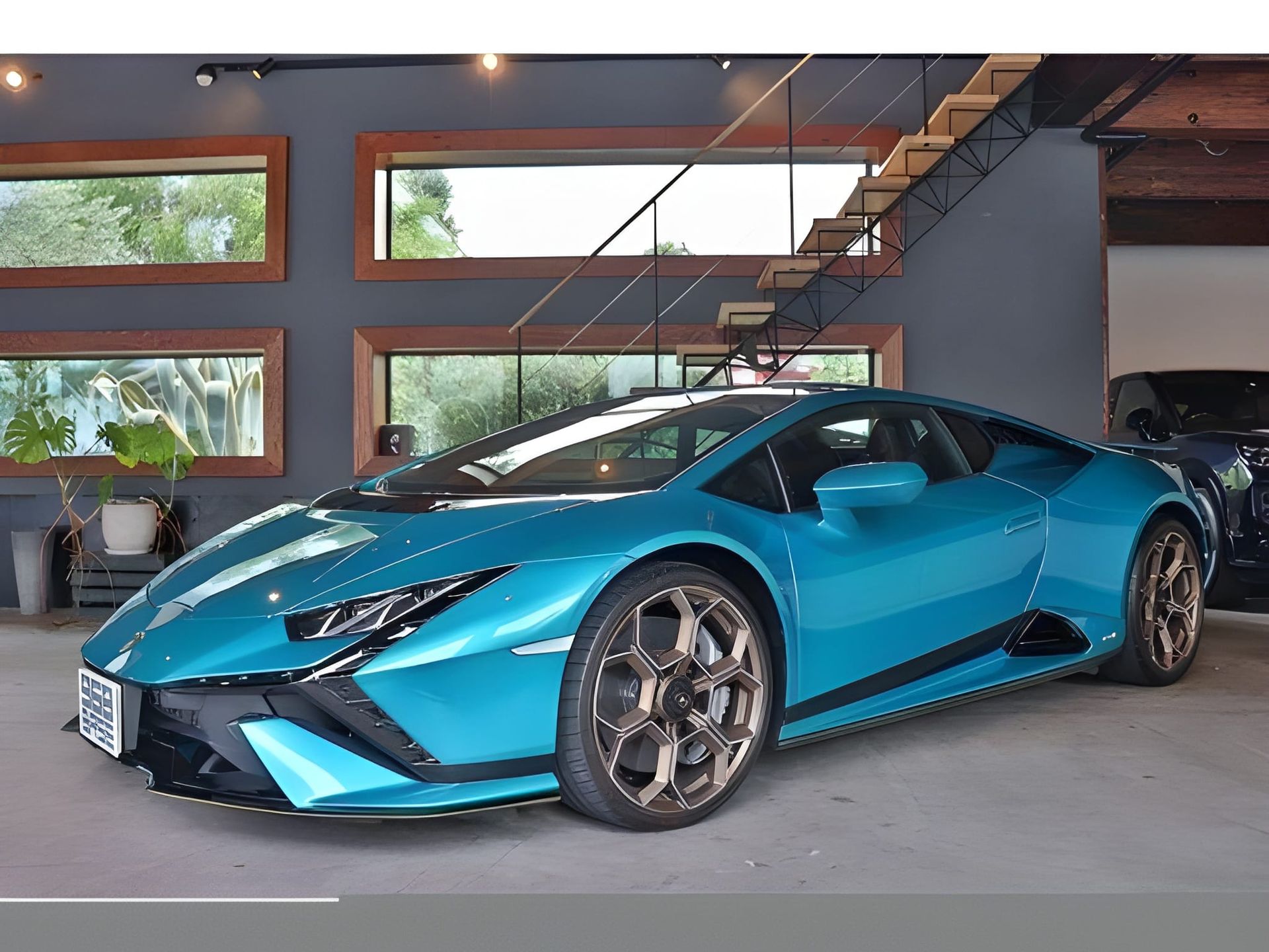 Blue Lamborghini sports car parked indoors, near a staircase and white car.