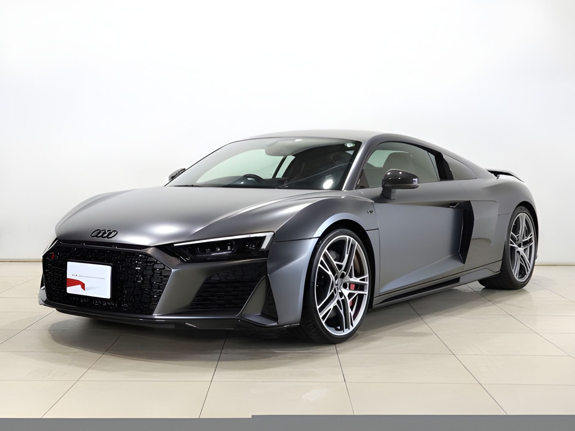 Gray Audi R8 sports car, front view, in a studio with a white background.