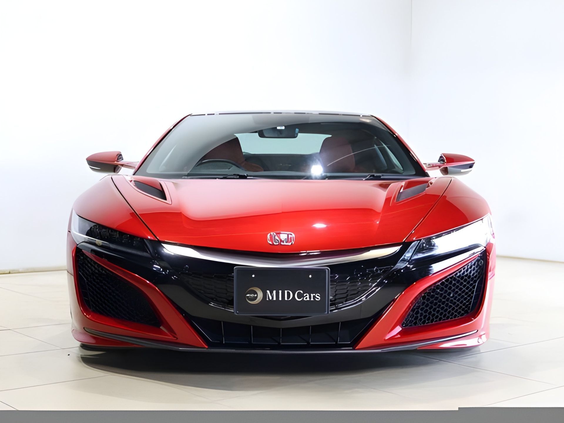 Red Honda NSX sports car, front view, with black accents.