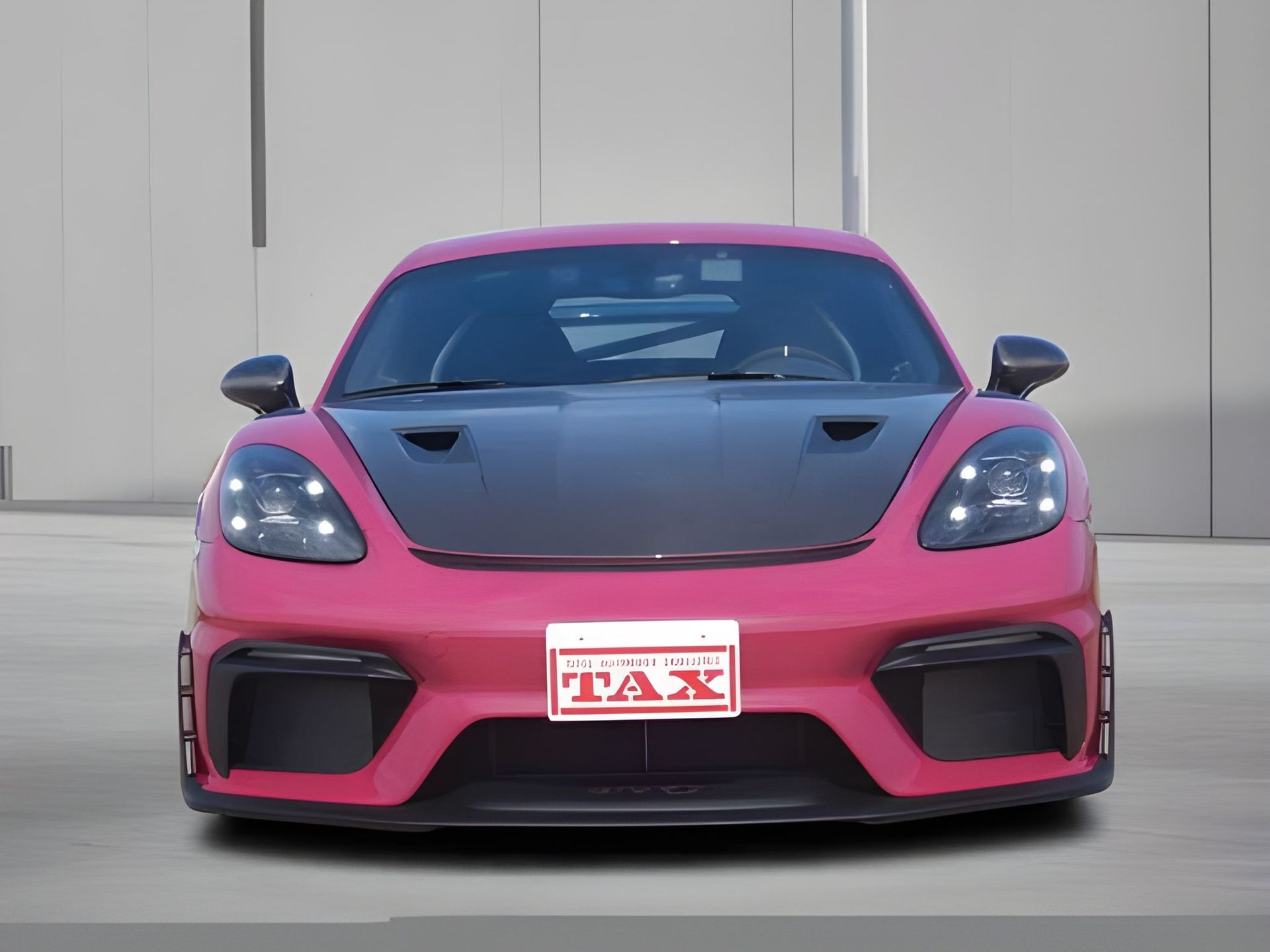 Pink Porsche sports car with black hood and black accents, license plate visible.