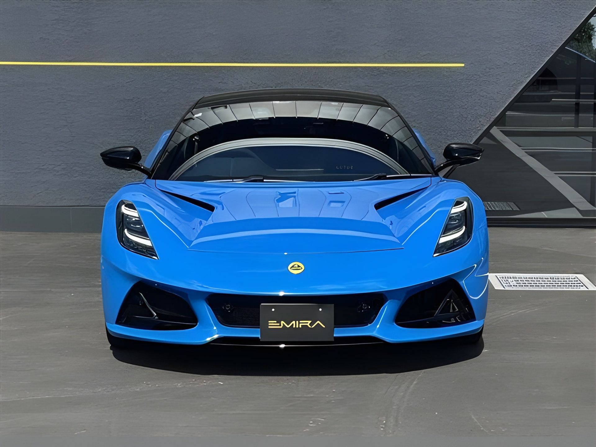 Blue Lotus Emira sports car parked in front of a building.