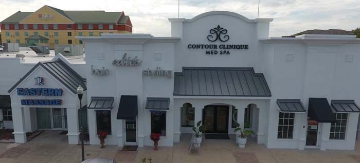 An aerial view of a white building with black awnings.