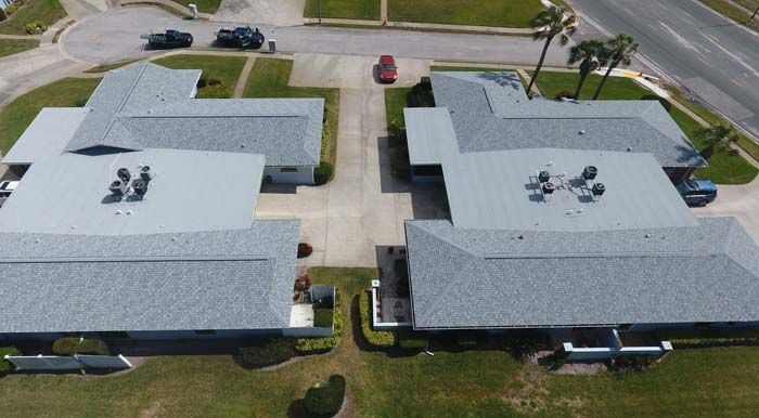 An aerial view of a group of houses with a gray roof.