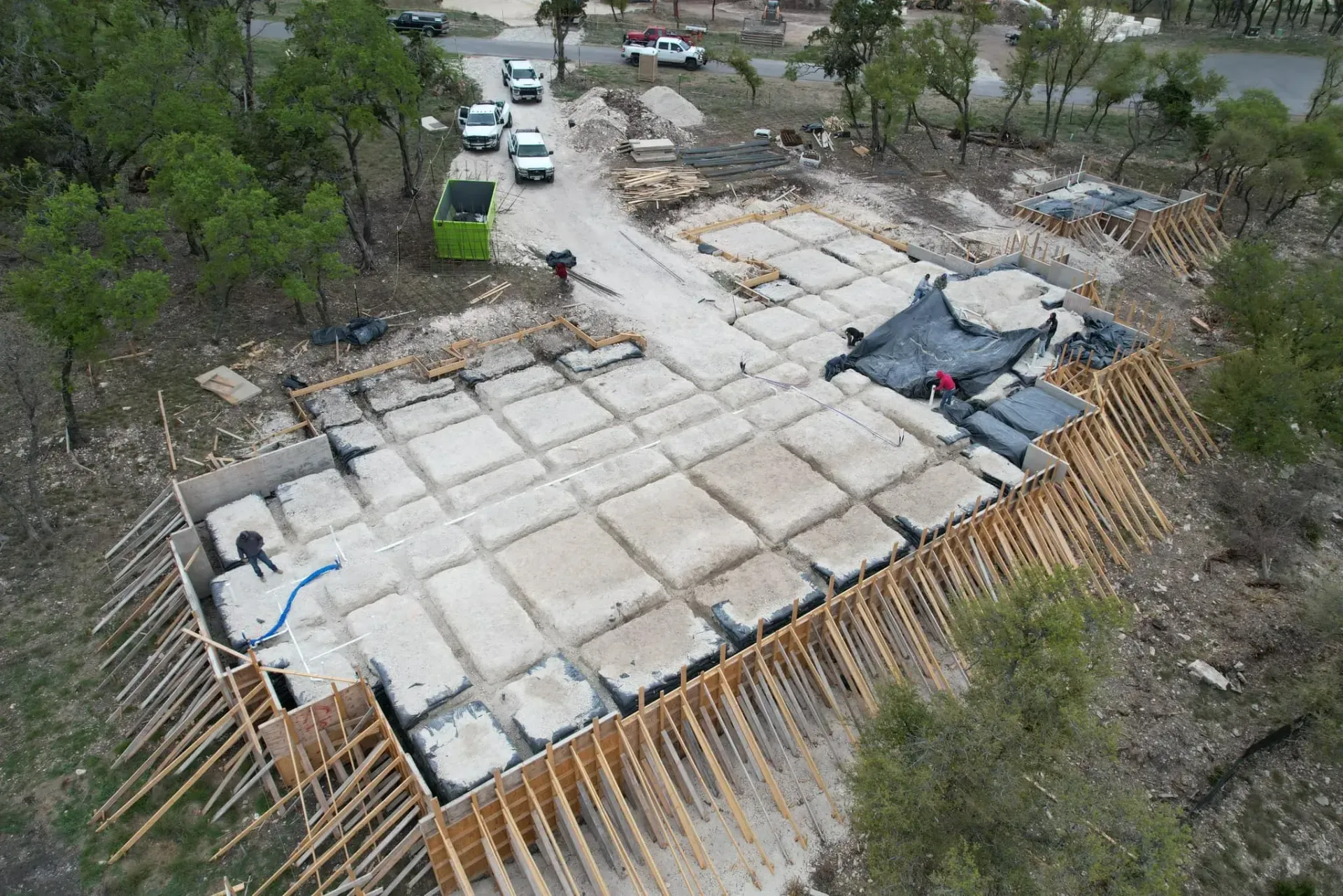 An aerial view of a building under construction in the middle of a forest.
