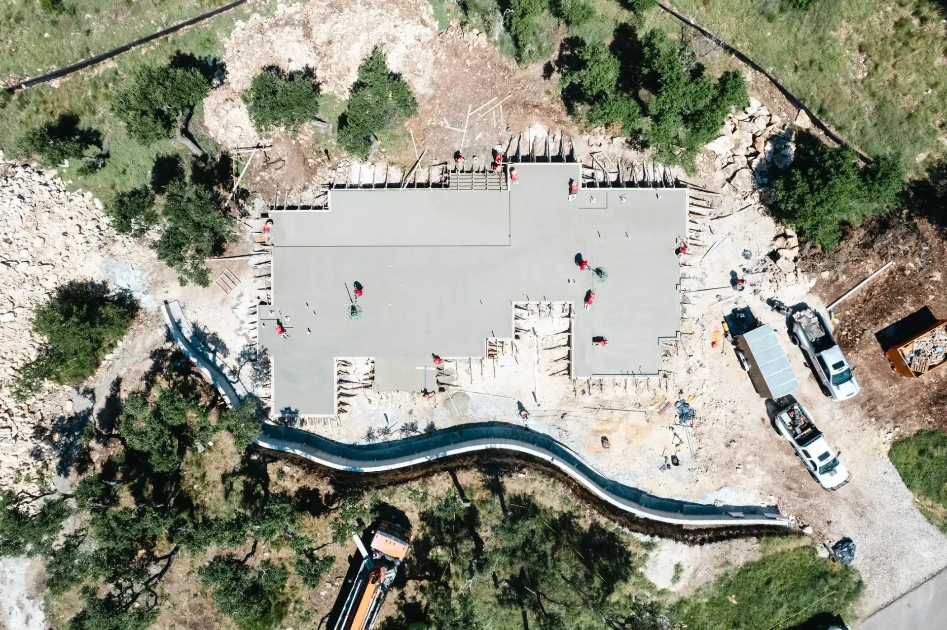 An aerial view of a building under construction surrounded by trees.