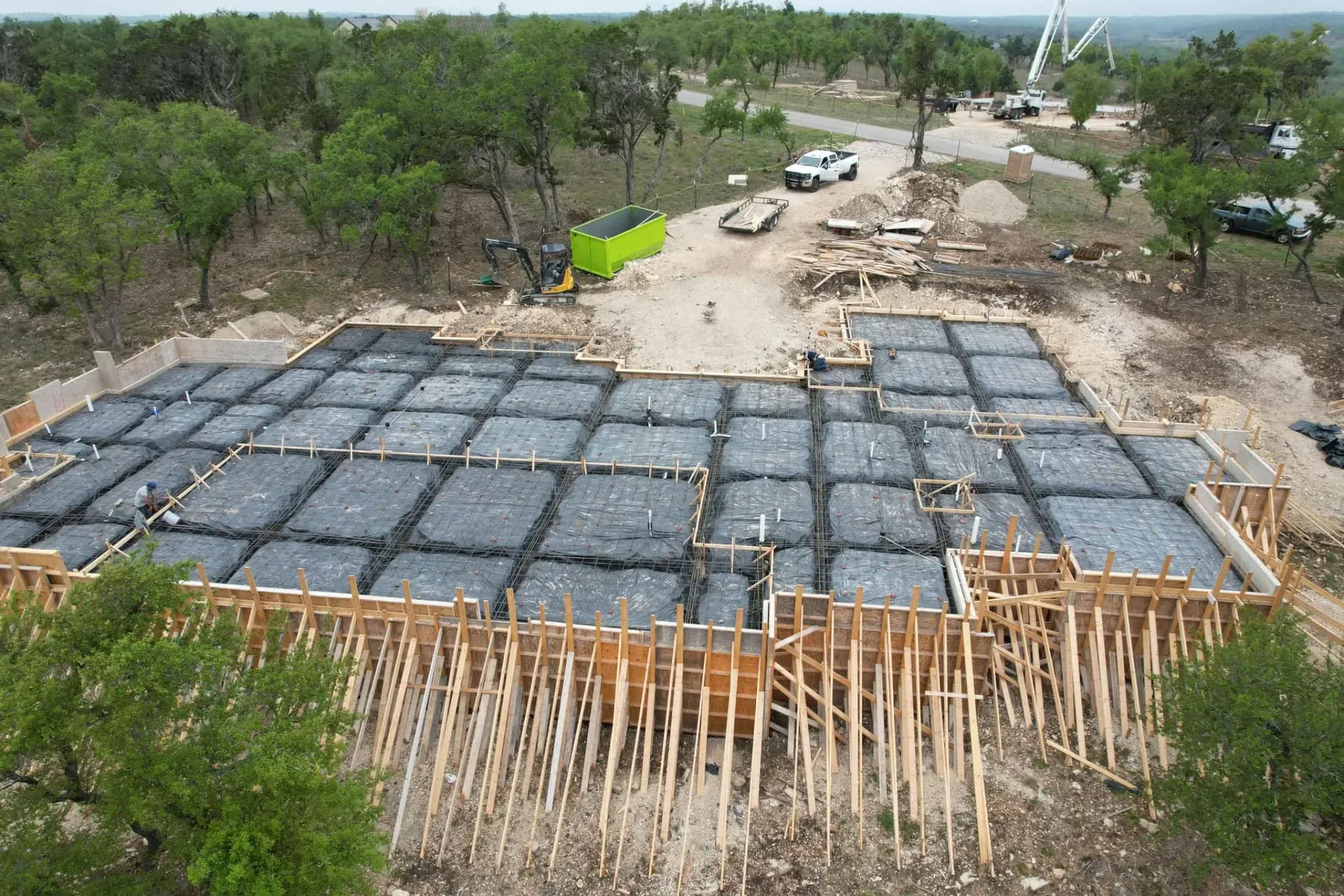 An aerial view of a building under construction in the middle of a forest.