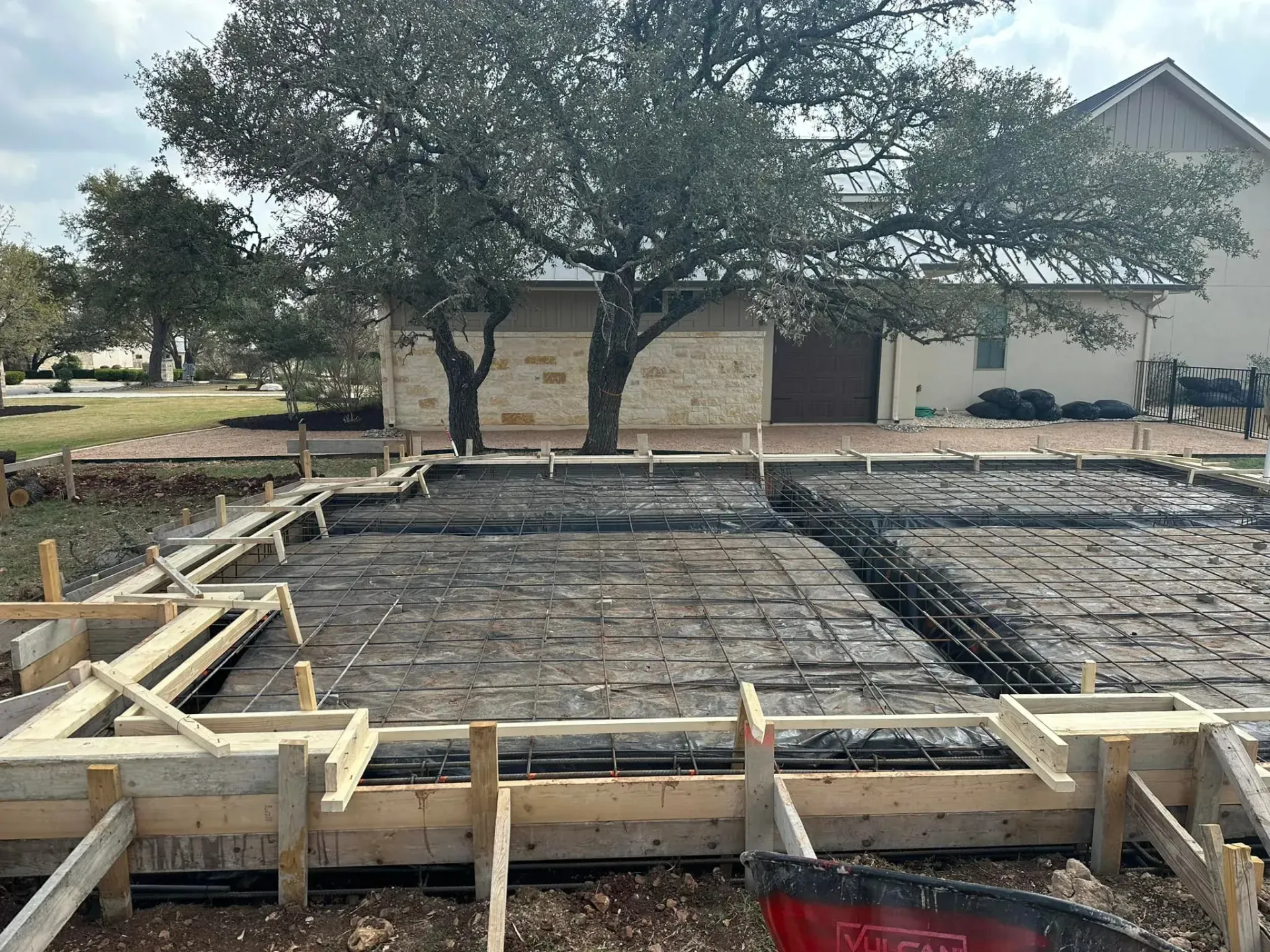 A house under construction with a tree in the background.