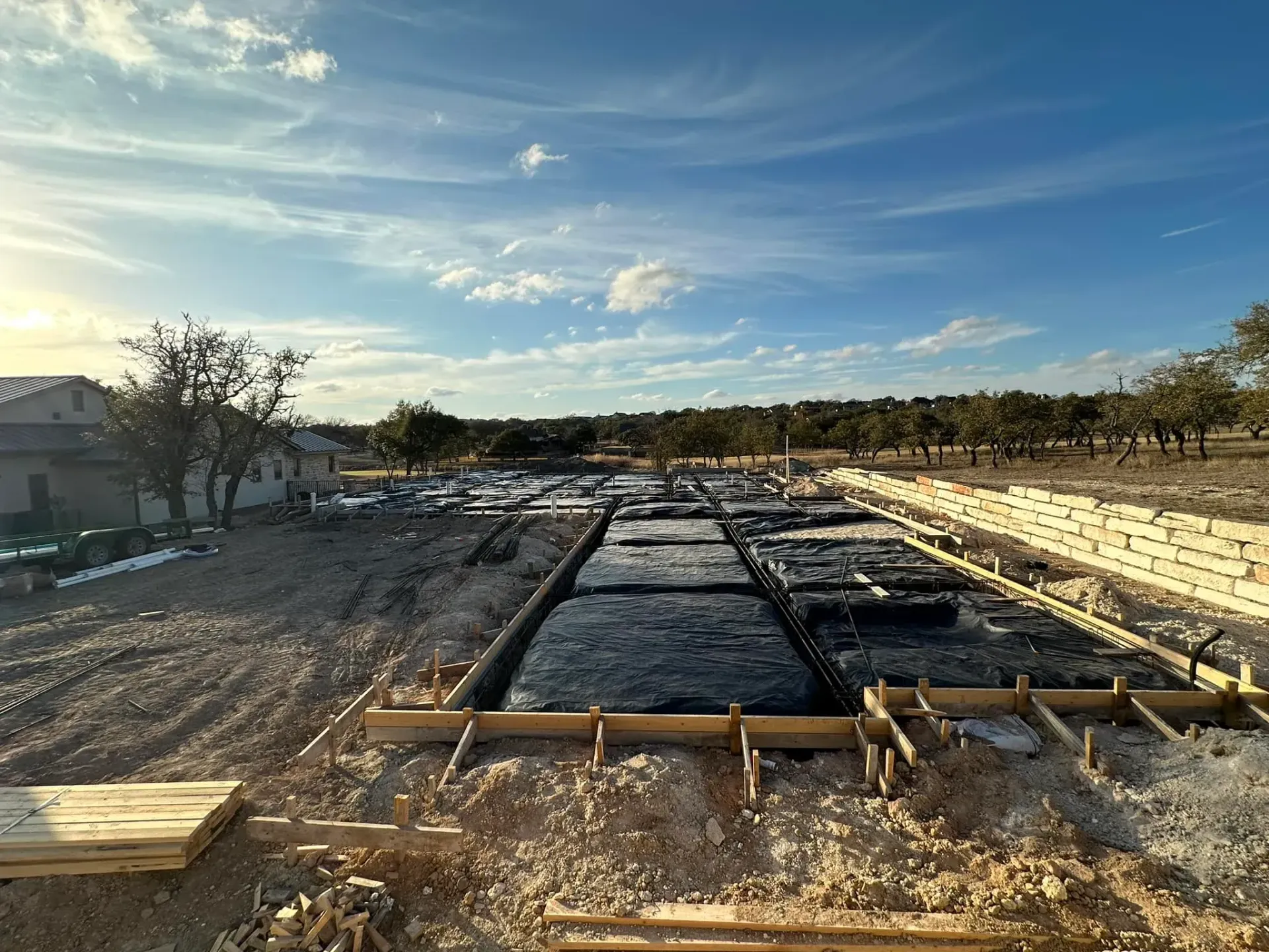 A construction site with a lot of dirt and trees in the background.