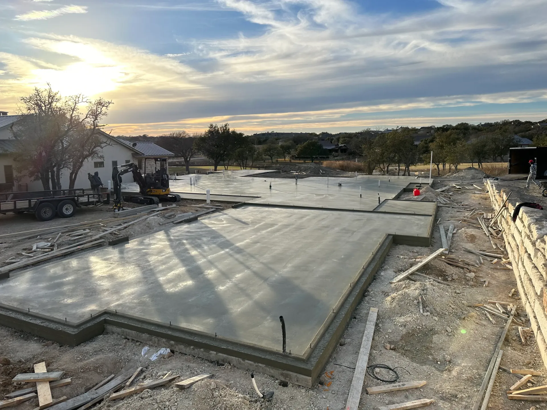 A large concrete slab is being poured on a construction site.