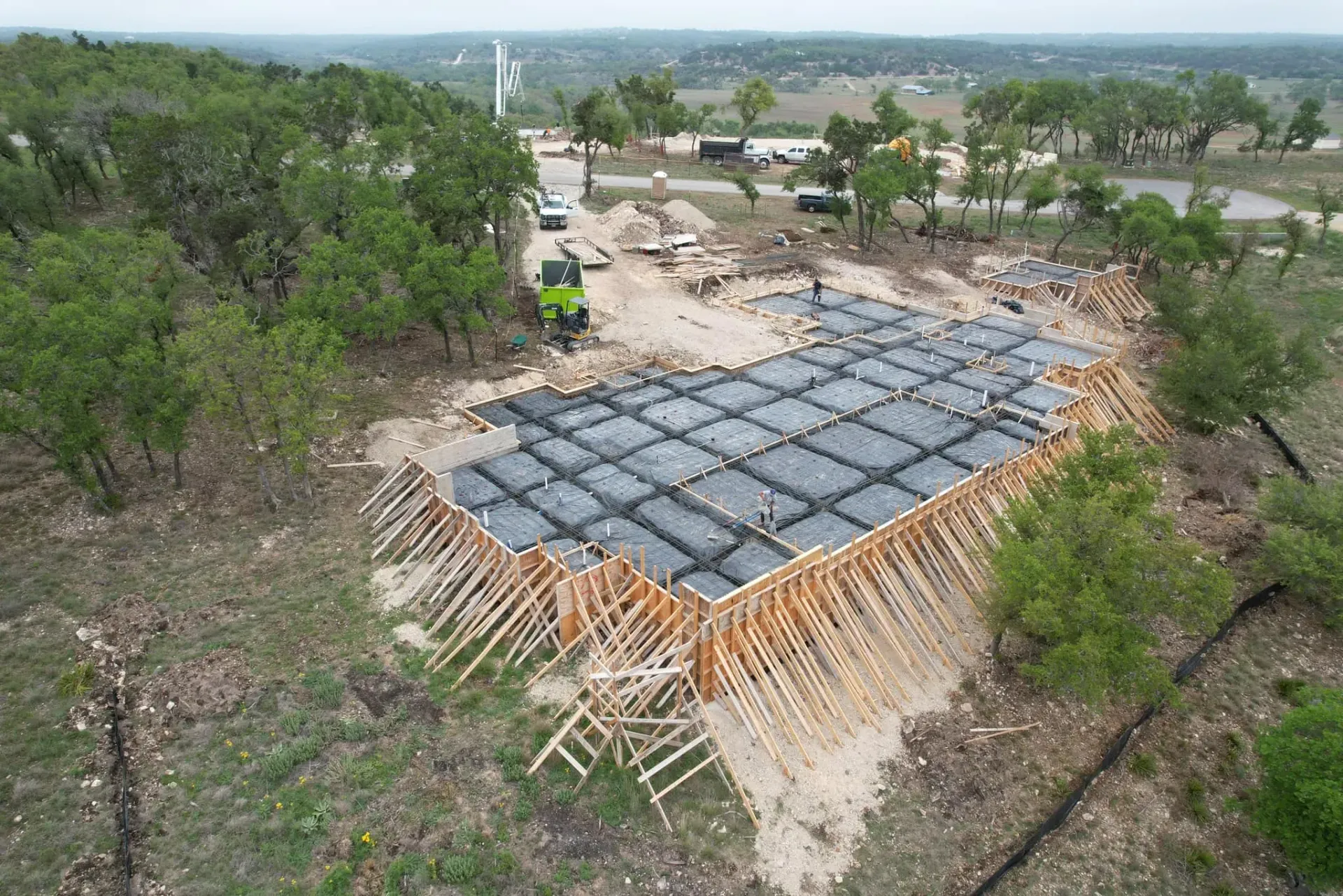 An aerial view of a construction site in the middle of a forest.