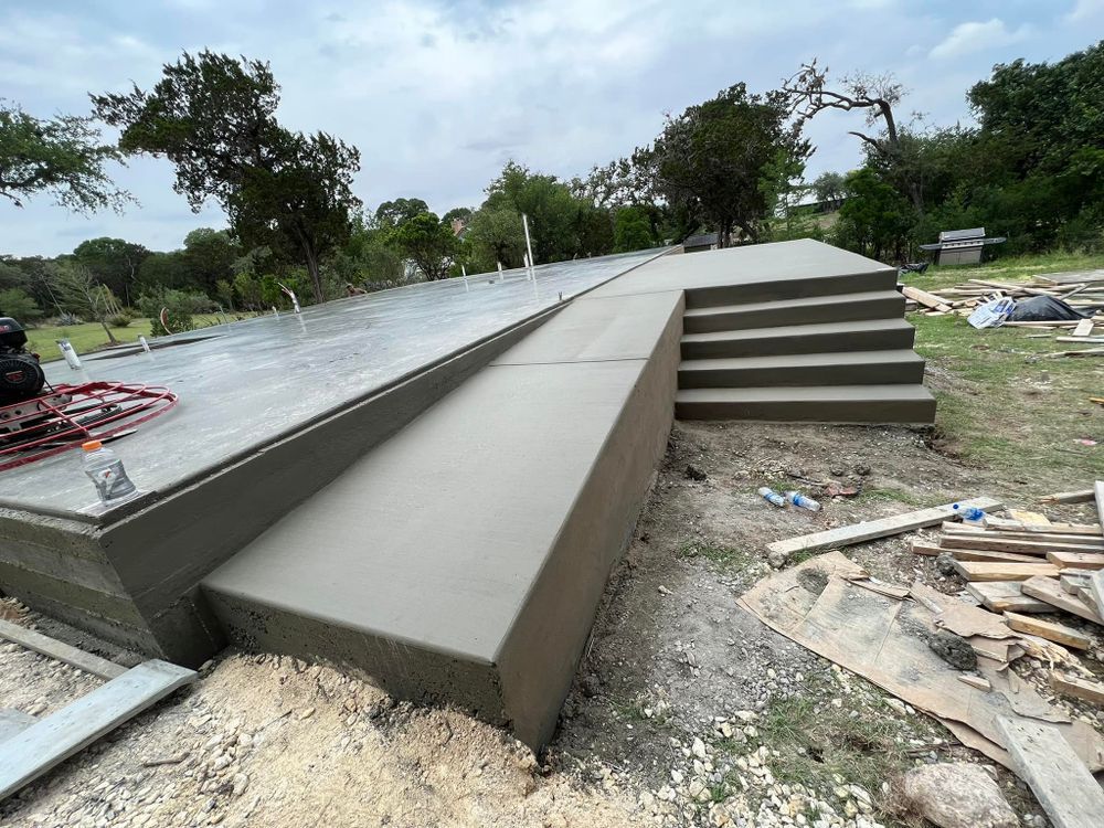 A concrete staircase is being built in a yard with trees in the background