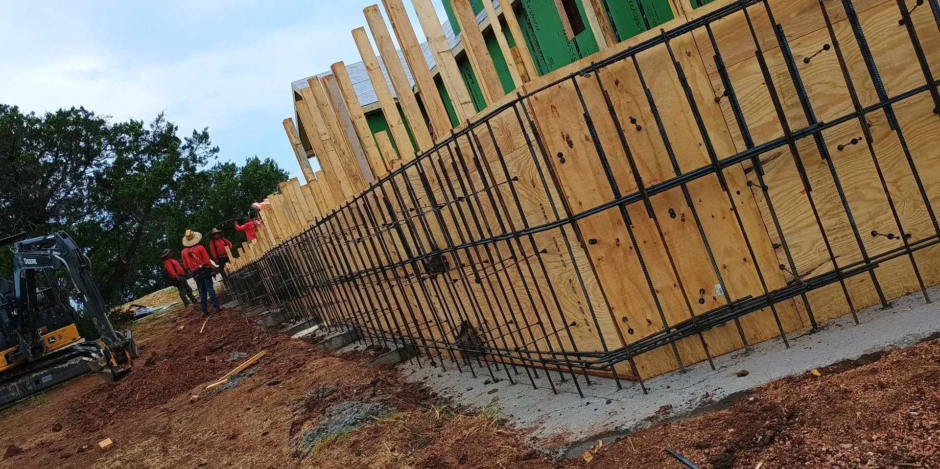 A large wooden fence is being built on top of a dirt hill.