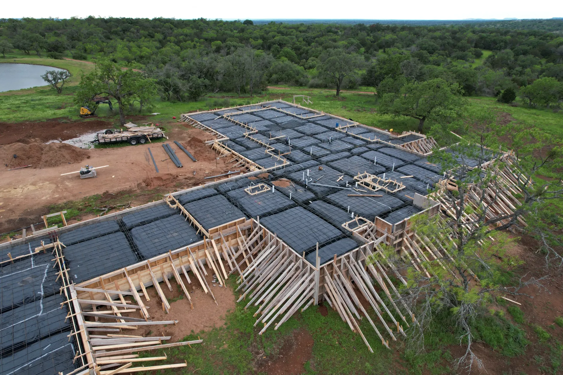 An aerial view of a building under construction in the middle of a field.