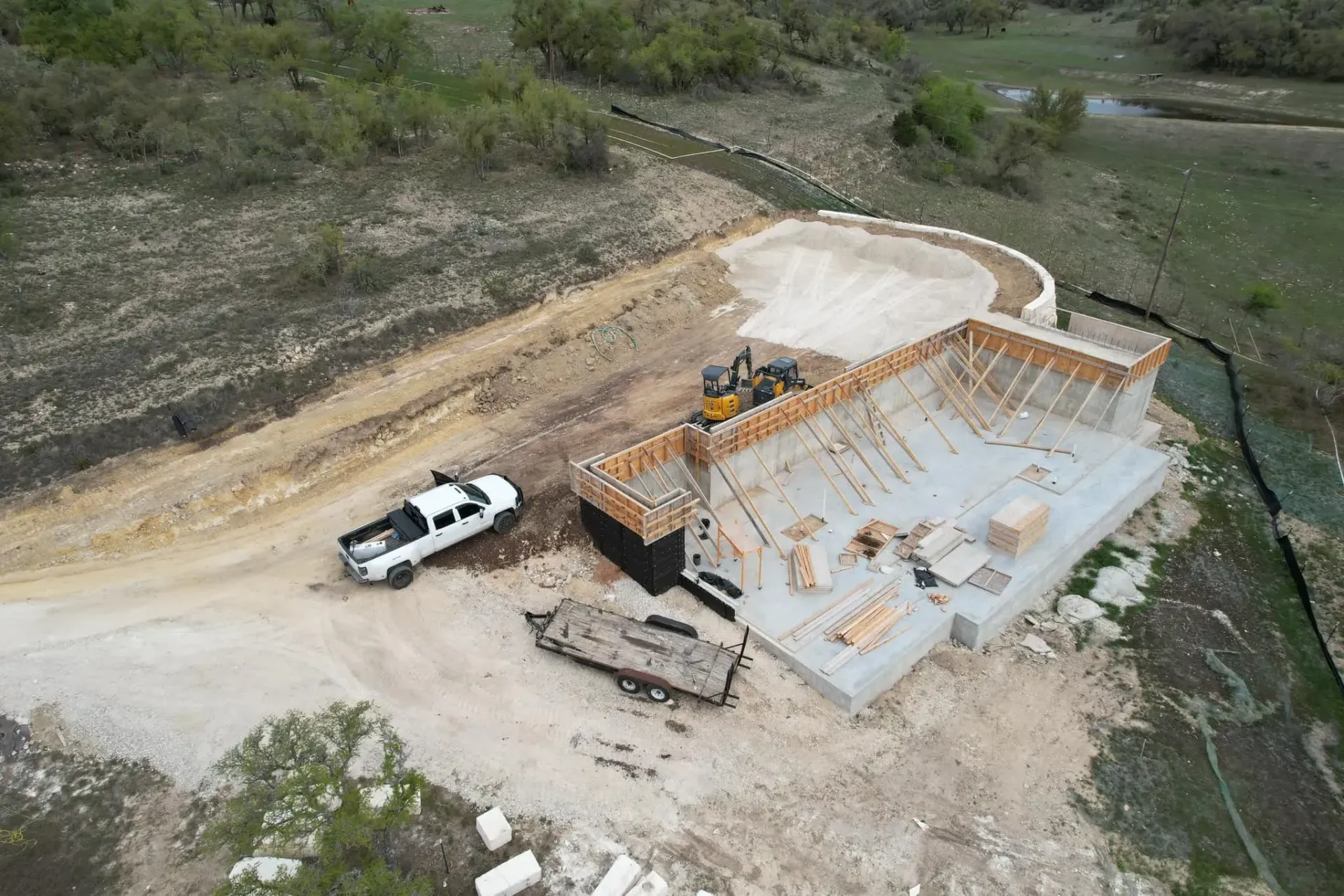 An aerial view of a construction site with a truck parked in the dirt.