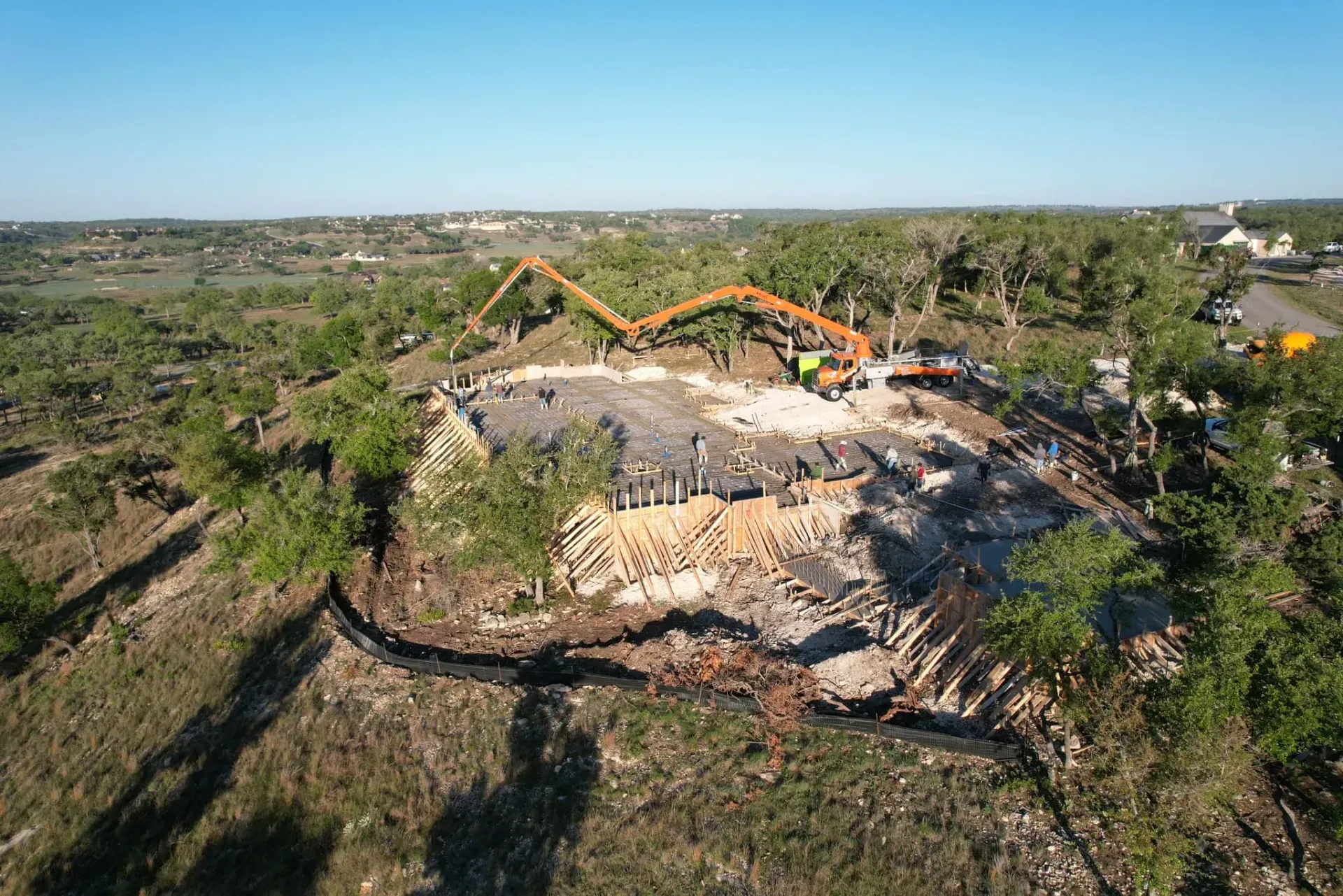 An aerial view of a construction site in the middle of a forest.