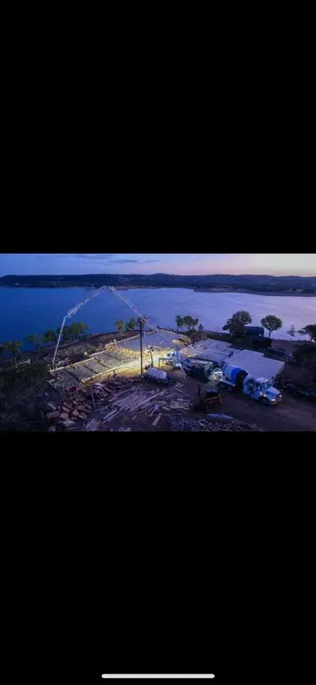 An aerial view of a lake with a lot of cars parked on the shore.