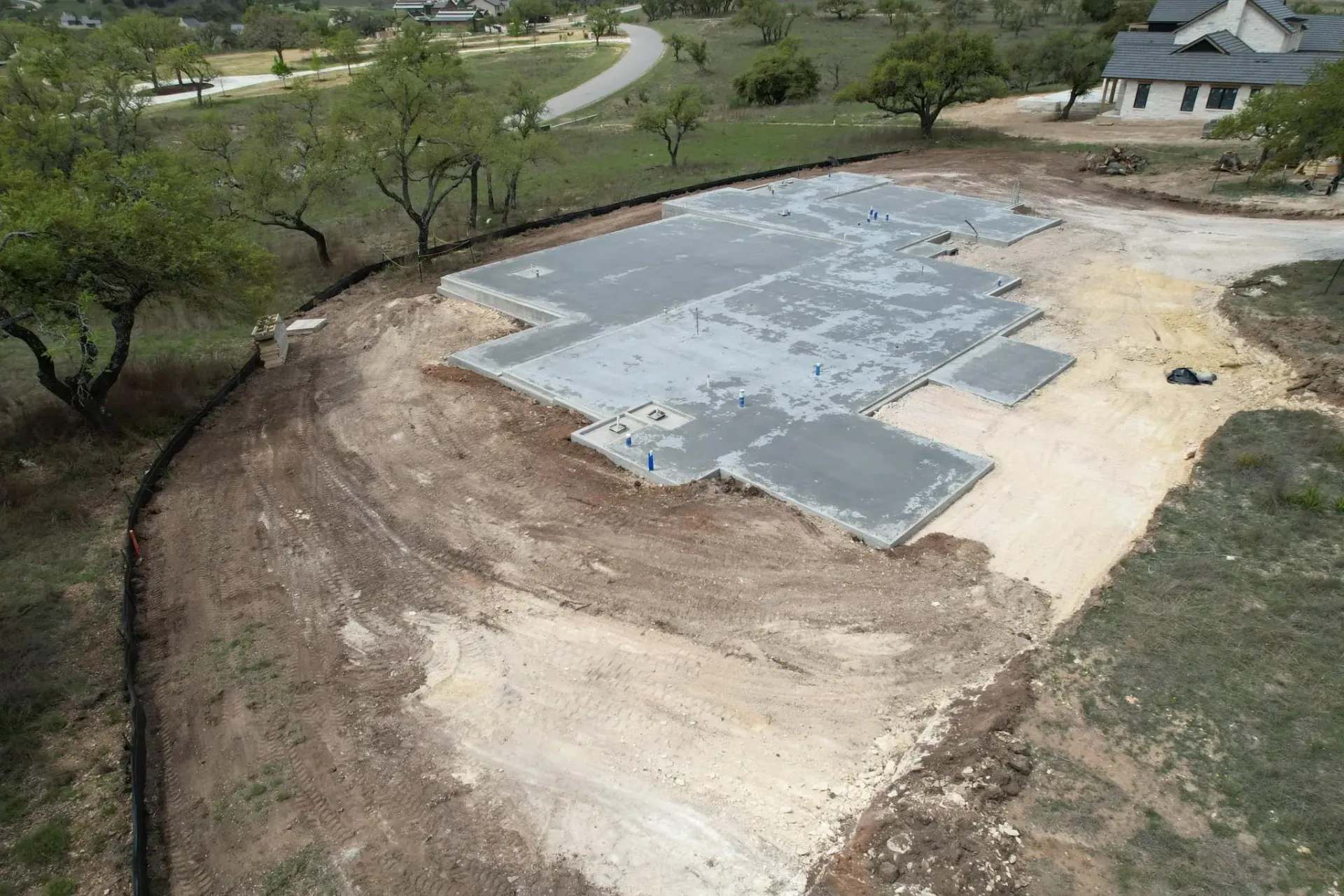 An aerial view of a dirt road leading to a house.