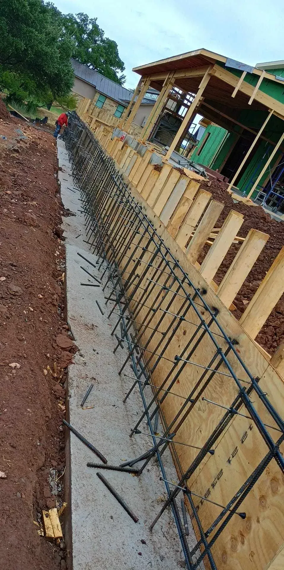 A concrete wall is being built in front of a house.