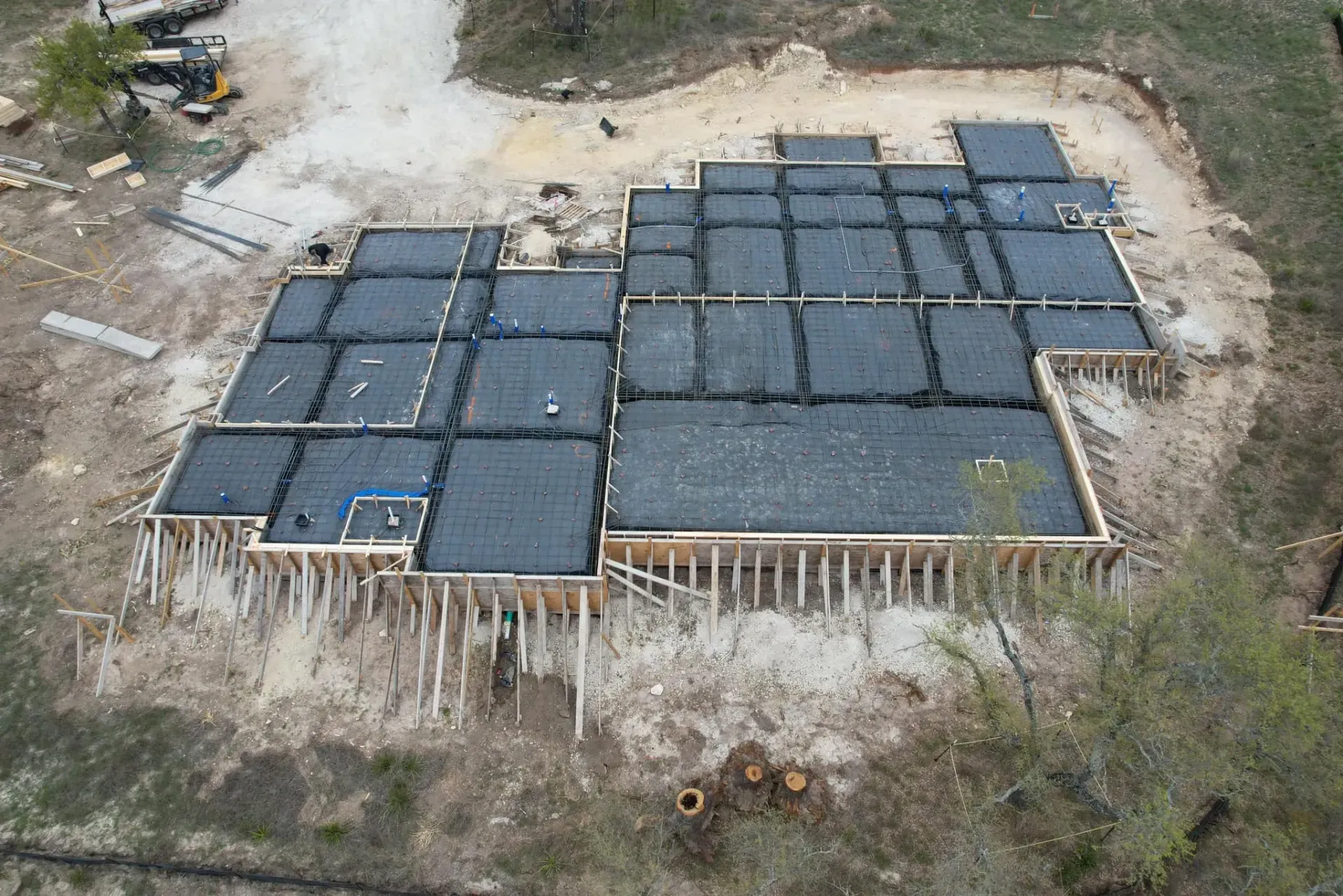 An aerial view of a building under construction in the middle of a field.