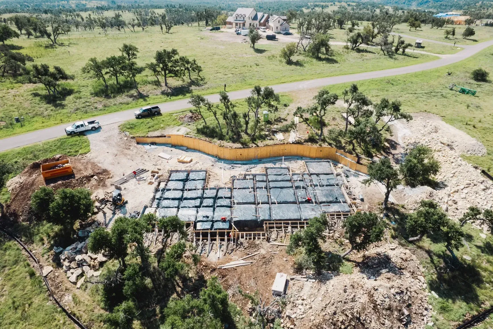An aerial view of a house under construction in the middle of a field.