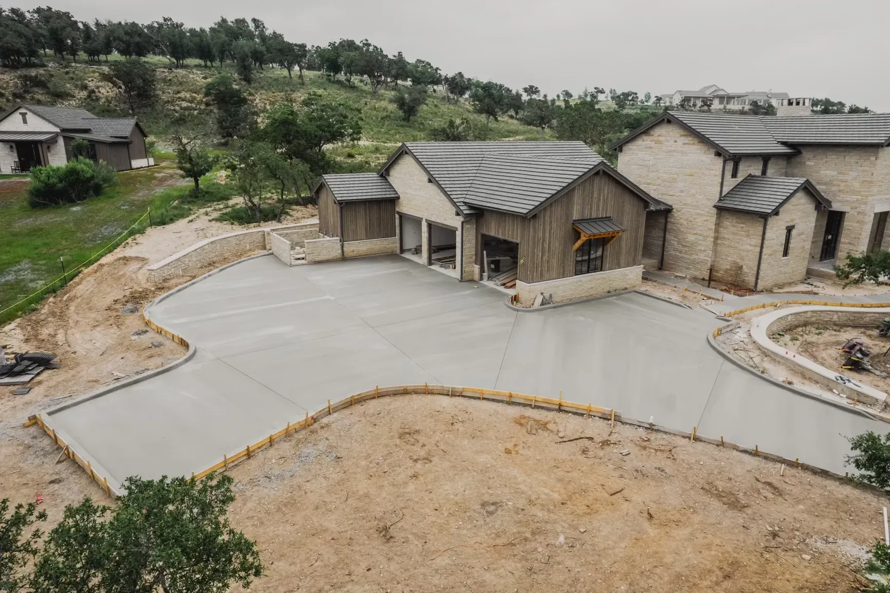 An aerial view of a house under construction with a concrete driveway.