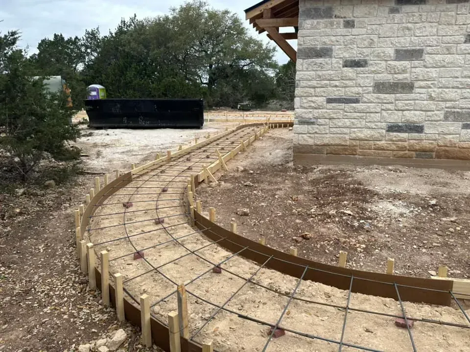 A concrete walkway is being built in front of a brick building.