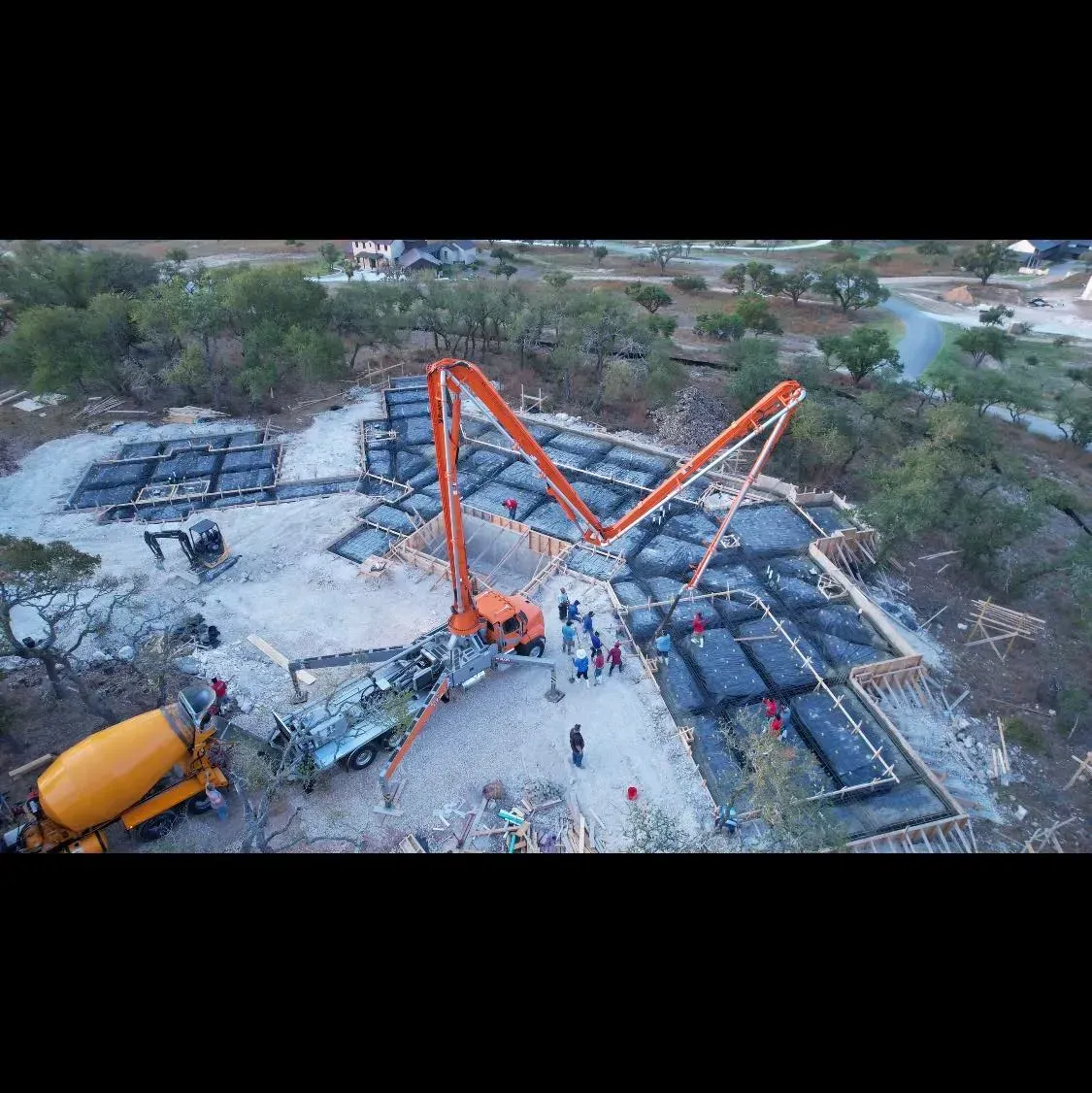 An aerial view of a construction site with a concrete pump.