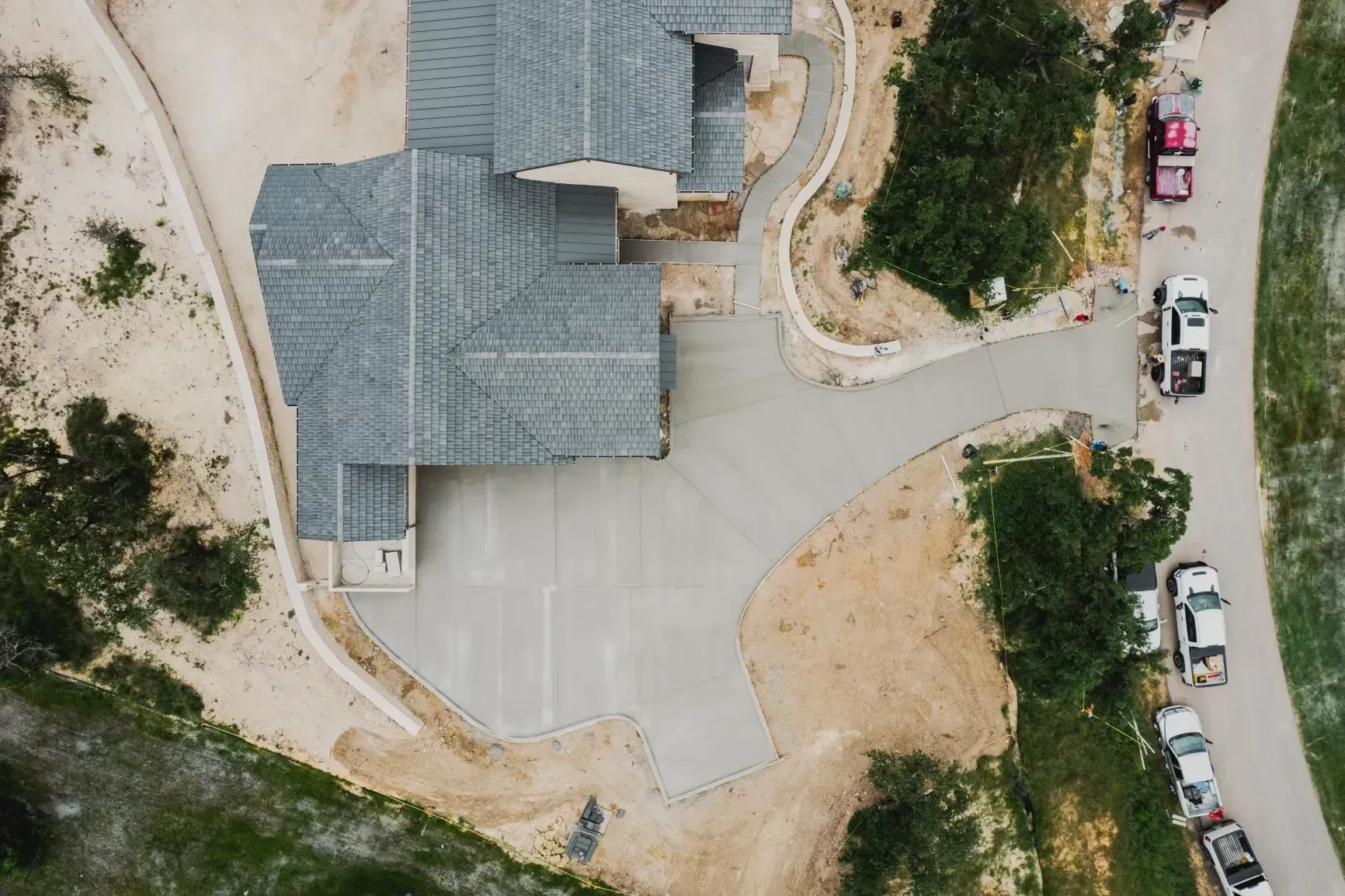 An aerial view of a house under construction with a lot of cars parked in front of it.