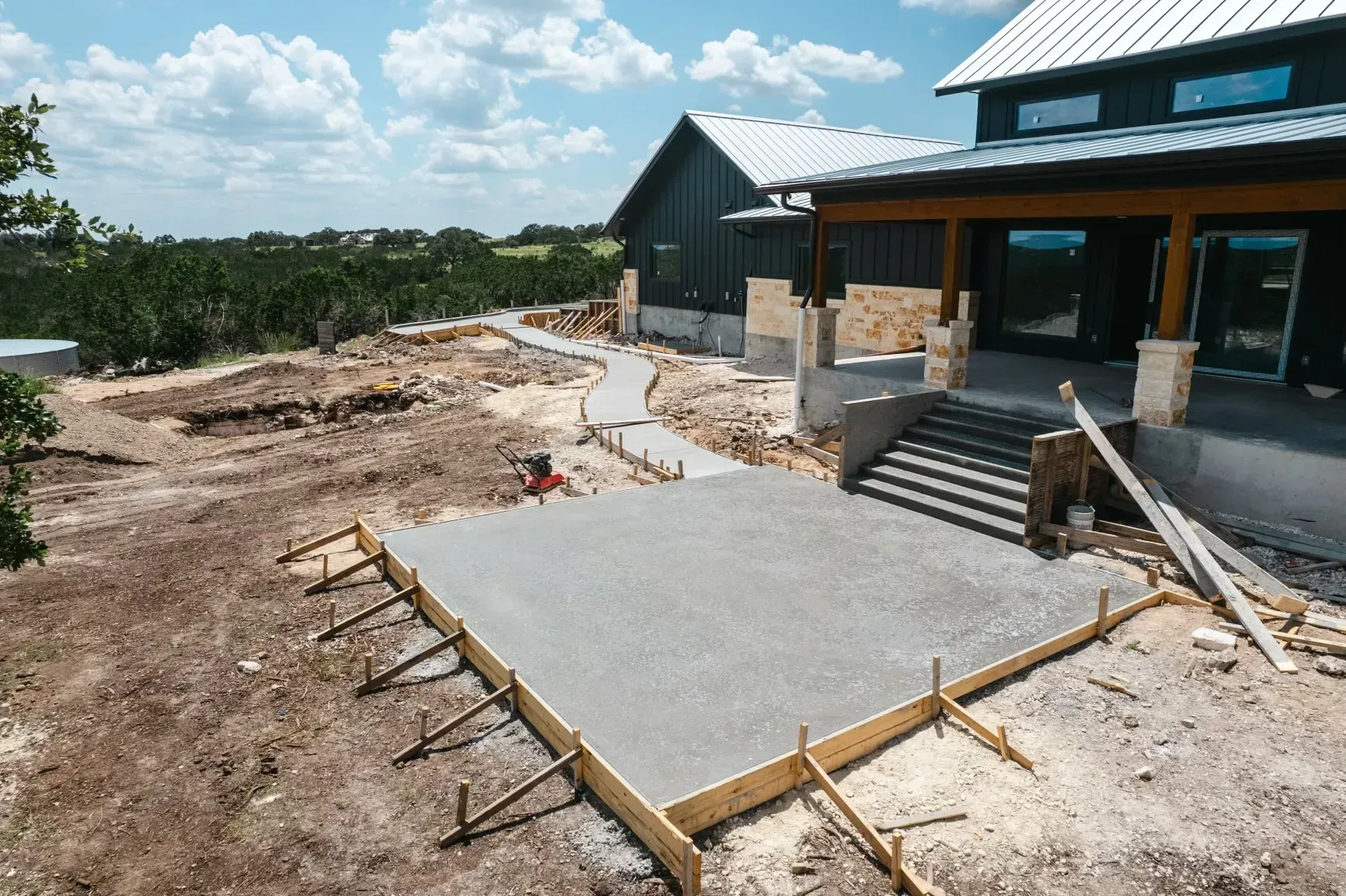 A concrete driveway is being built in front of a house.