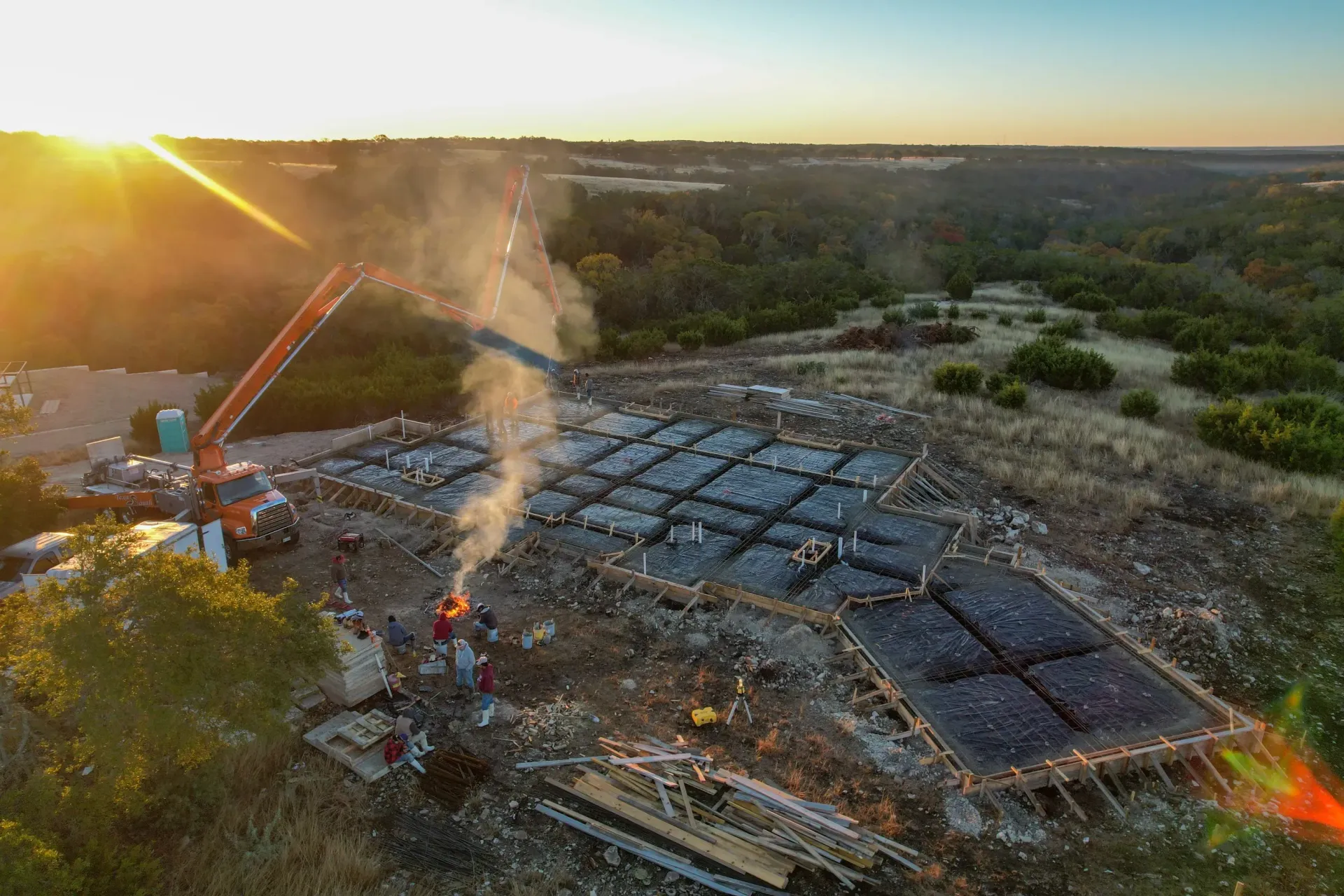 An aerial view of a construction site with smoke coming out of the ground.