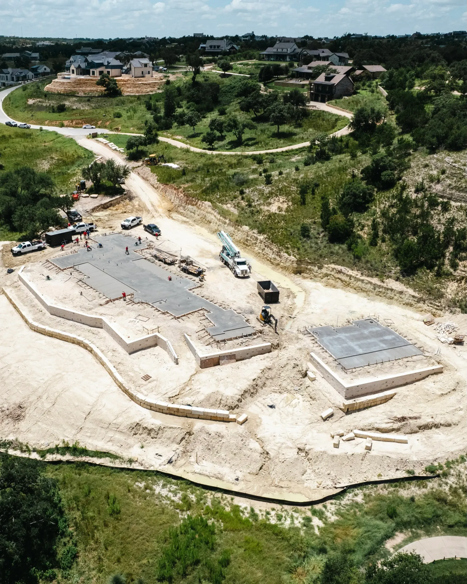 An aerial view of a construction site with a lot of dirt and trees
