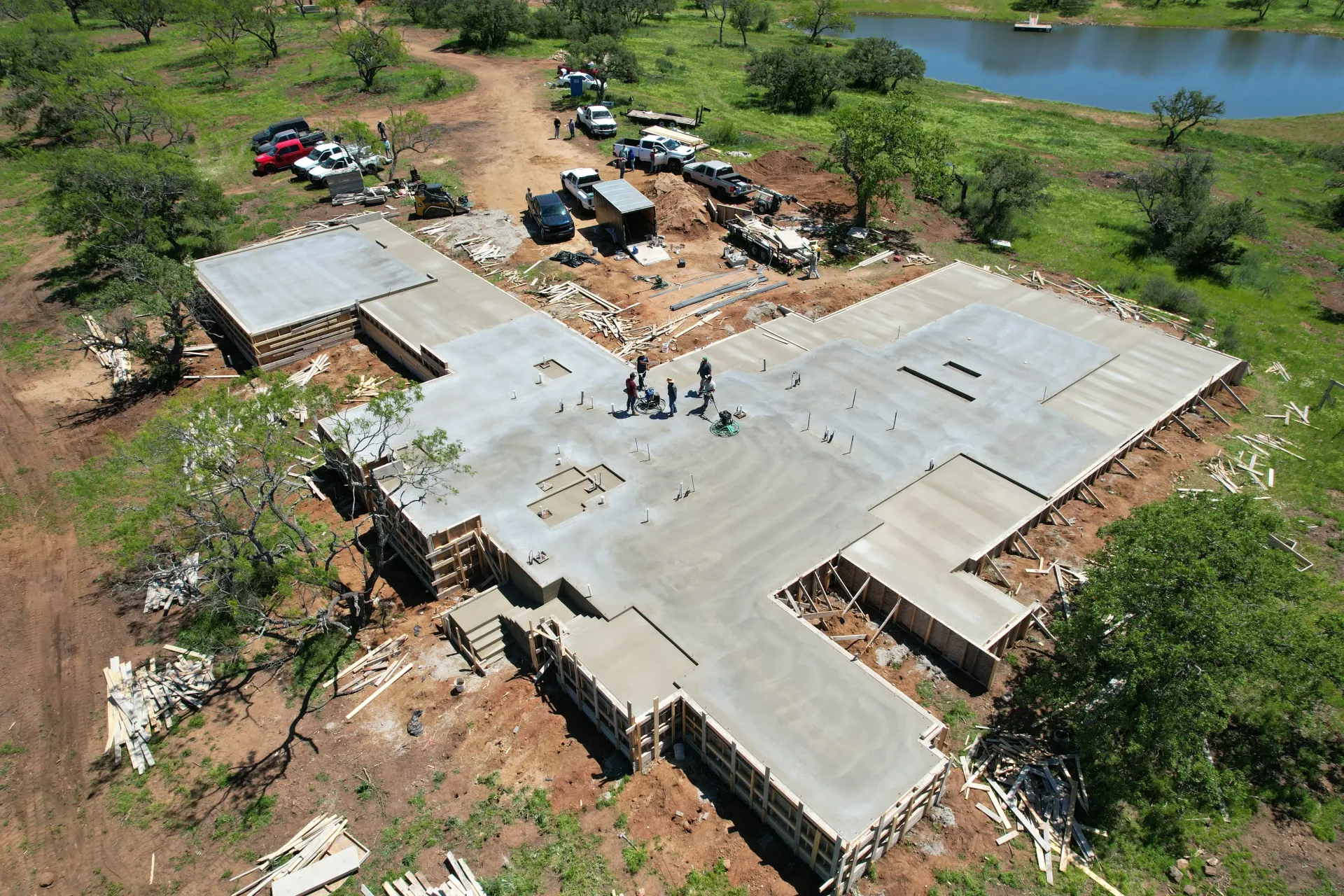 An aerial view of a construction site with a lake in the background
