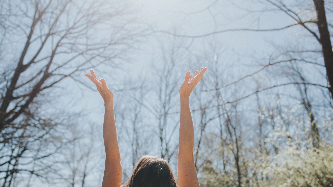 Woman raising her arms toward the sky, Lori Zabka Wellness Blog Post