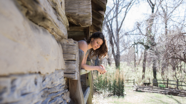 Lori Zabka Wellness Blog Post, woman lookout the window of a log cabin
