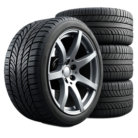 A stack of four black tires with aggressive tread patterns, with one silver five-spoke alloy wheel leaning against them.