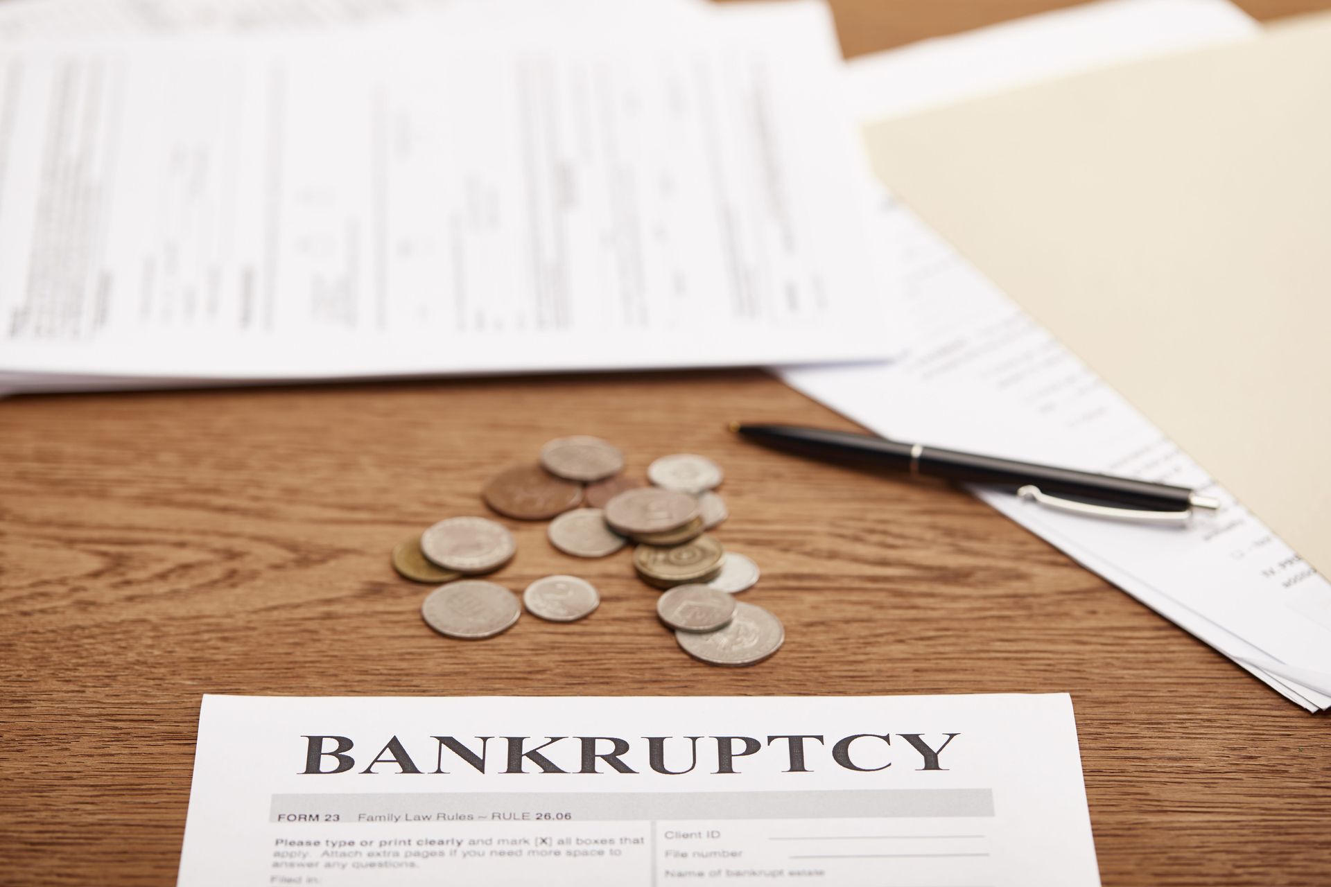 Bankruptcy document on desk with scattered coins and papers